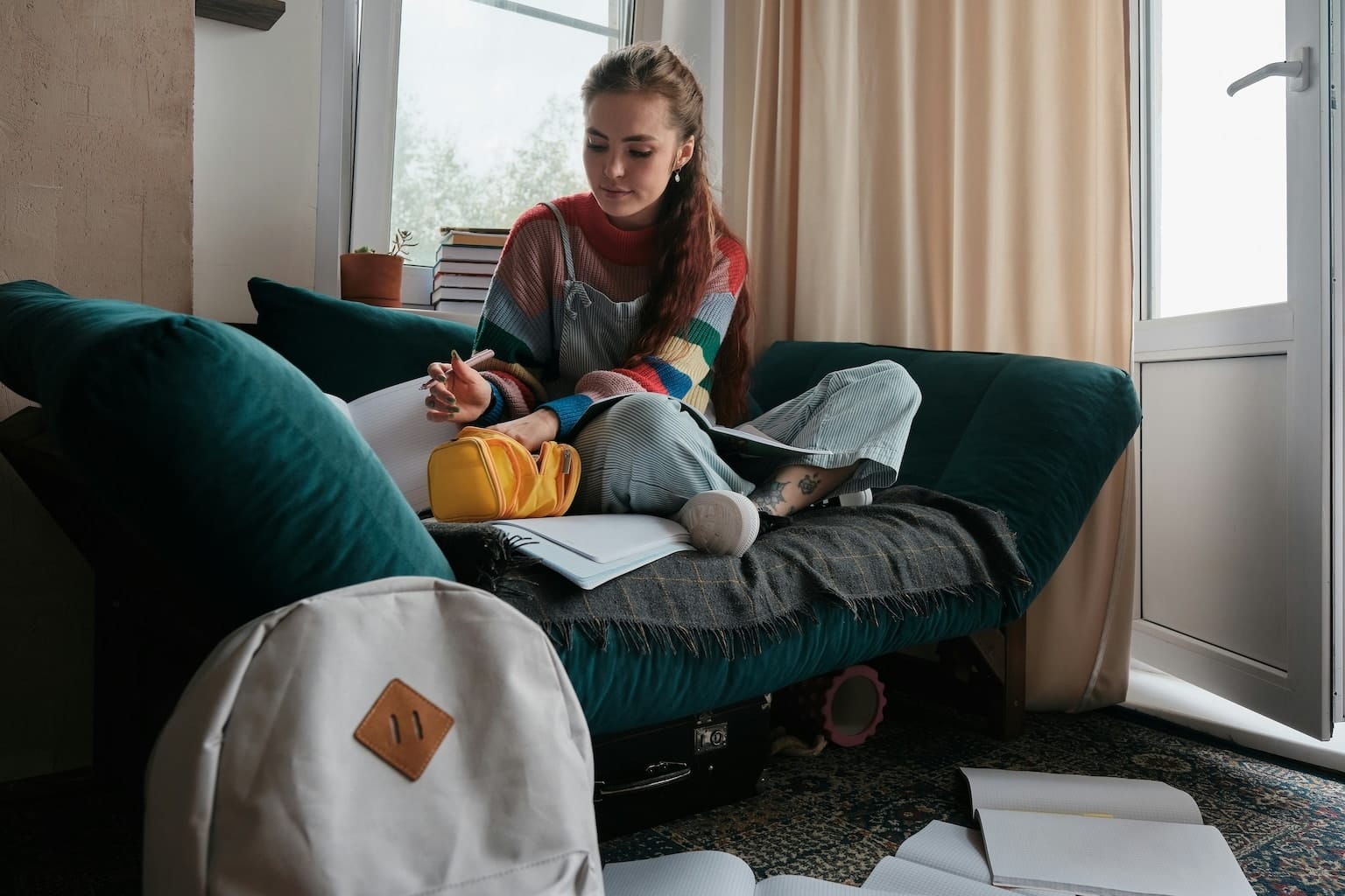 Female student reading her study materials at her dorm.